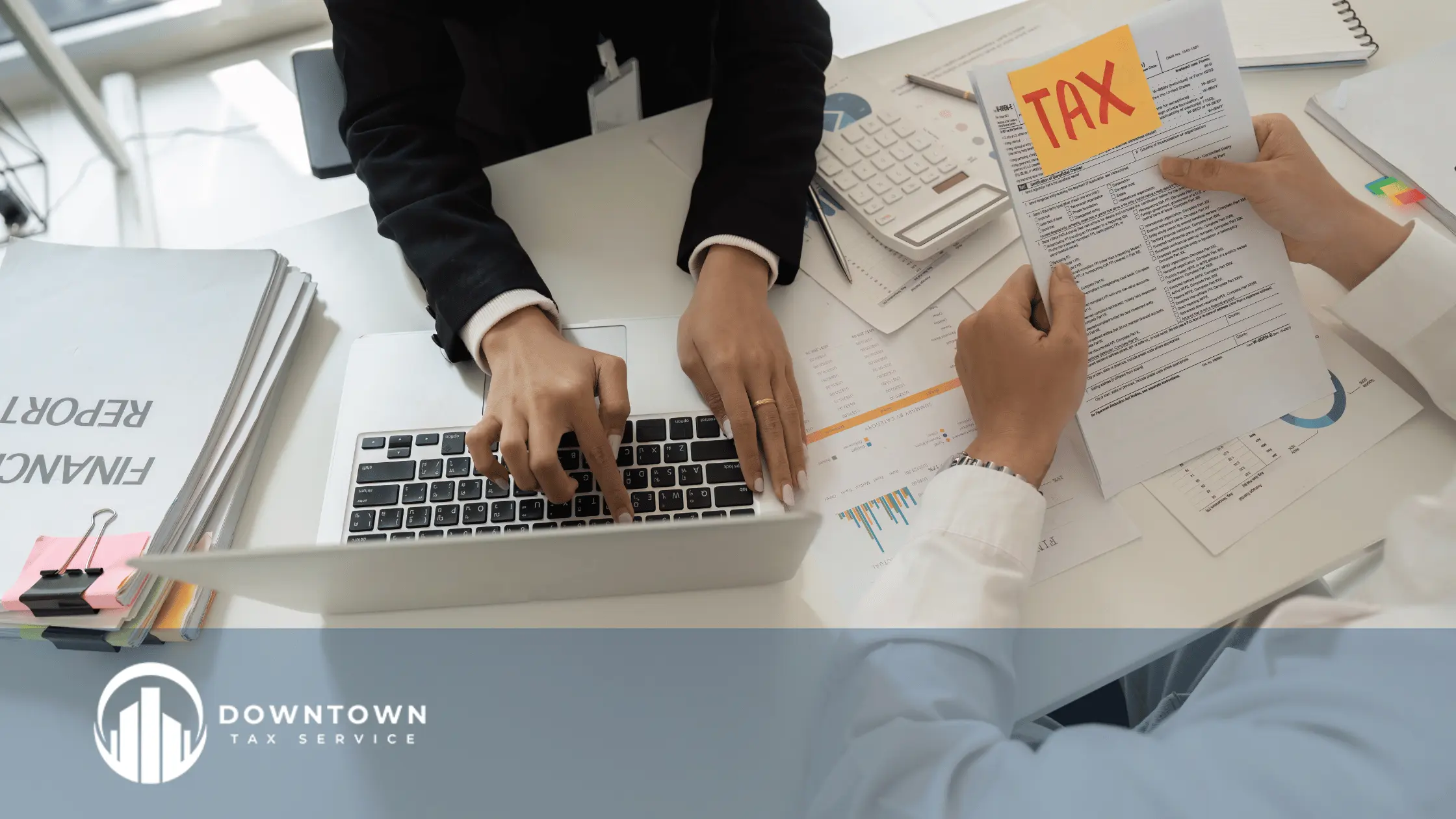 Organized tax documents on a desk with a laptop and notebook